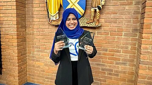 Photo of Raihaanah Ahmed with two awards